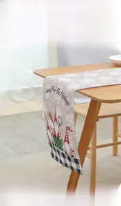 Linen Christmas table runner with gnomes and snowflakes on a wooden dining table