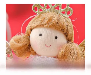 Detailaufnahme eines Weihnachtsengel-Puppengesichts mit goldener Krone und Glitzer