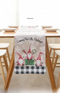 Close-up of linen Christmas table runner featuring three gnomes and black white plaid