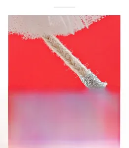 Detailed close-up of woven hemp rope with silver tinsel wrap and soft white fringe tassels