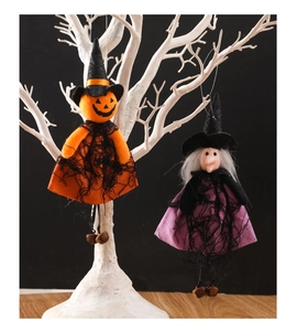 Detail of hanging Halloween dolls with pumpkin and witch themes on white branches