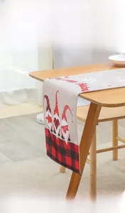 Close-up of Christmas table runner with red plaid gnomes and Merry Christmas text