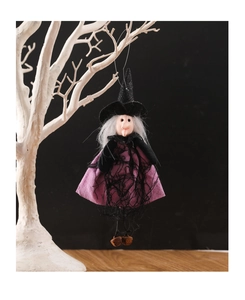 Detailed view of a purple witch hanging decoration with bells and black wizard hat