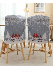Detail of Christmas chair covers with gnome and snowflake patterns in a cozy dining room