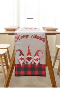 Detail of Christmas table runner with gnomes and Merry Christmas print on wooden table