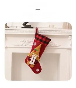 Primer plano de un calcetín navideño rojo con gnomo y copos de nieve en la chimenea