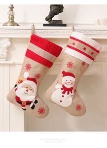 Detail of burlap Christmas stockings with Santa and Snowman embroidery hanging on a fireplace
