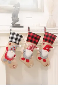 Three-piece burlap Christmas stockings set with gnomes hanging on a white fireplace