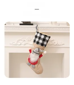Close-up of burlap Christmas stocking with 3D gnome design hanging on a white fireplace