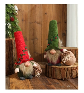 Close-up of handmade Christmas gnomes with spiral hats and burlap bags on rustic wood logs