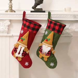 Calcetines de Navidad de gnomo en fieltro rojo y verde colgados en una chimenea blanca decorativa