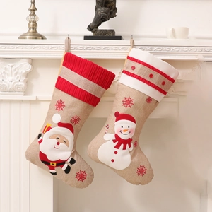 Set of 2 burlap Christmas stockings with Santa and Snowman hanging on a fireplace mantel