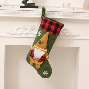 Calcetín de Navidad verde con gnomo y cuadros colgado en una chimenea blanca