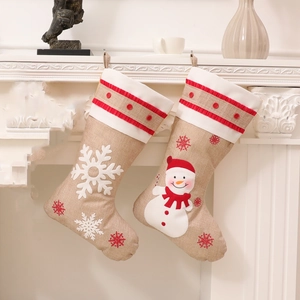 Hessian burlap Christmas stockings with 3D snowman and snowflake on a white fireplace