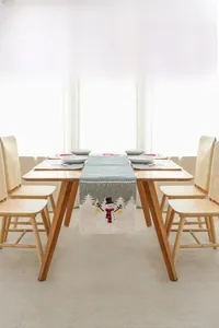 Détail d'un chemin de table de Noël et de sets de table avec bonhomme de neige sur bois
