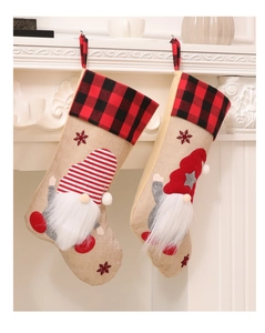 Detail of two burlap Christmas stockings with gnome embroidery hanging on white fireplace