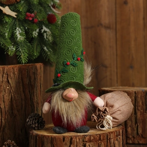 Christmas gnome doll with green pointed hat and red body on rustic wooden stump