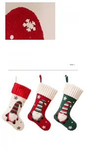 Dettagli delle calze di Natale bianche, rosse e verdi con motivi a fiocco di neve a maglia