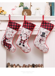 Close-up of Santa, snowman and reindeer Christmas stockings hanging on a white fireplace
