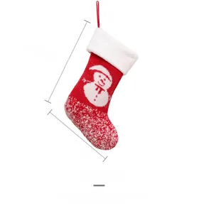 Detail showing red knitted Christmas stocking with white snowflake and snowman embroidery