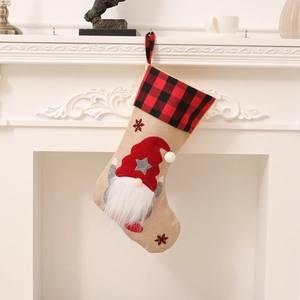 Nordic Christmas gnome stocking with red plaid cuff and snowflake embroidery hanging on fireplace