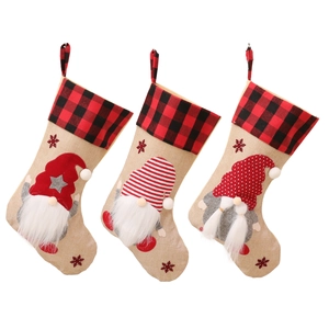 Three Nordic Christmas stockings with gnomes and red snowflakes on burlap fabric