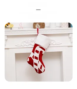 Classic red and white Christmas stocking with candy cane pattern hanging on white fireplace