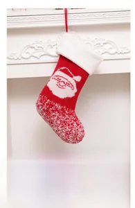 Close-up of red knitted Christmas stocking with Santa Claus design and white faux fur trim