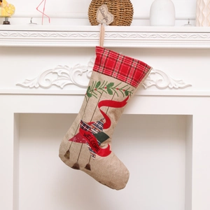 Linen Christmas stocking with red plaid cuff and Welcome banner on a white fireplace