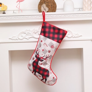 Classic buffalo plaid Christmas stocking with reindeer silhouette hanging on a white fireplace