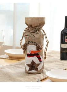 Detail der Weihnachts-Schneemann-Stickerei auf einer Sackleinen-Weinflaschenhülle