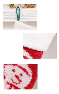 Detail of green hanging loop, plush white cuff and knitted Santa Claus on Christmas stocking