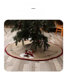 Detail of burlap Christmas tree skirt featuring snowman embroidery and red plaid borders