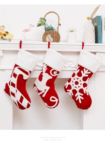 Detail of red and white embroidered Christmas stockings hanging on a white fireplace