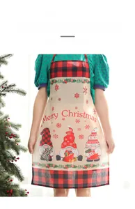Detail of Christmas apron with red plaid pattern and three festive gnomes motif