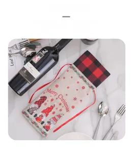 Detail of Christmas gnome wine bag with red drawstring on marble surface