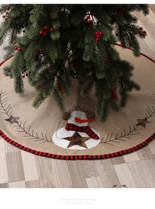 Macro detail of burlap Christmas tree skirt with snowman JOY embroidery and plaid border