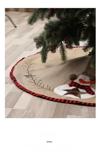 Detailed close-up of burlap Christmas tree skirt with snowman embroidery and JOY star design