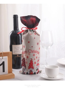 Detail of burlap Christmas wine bag with gnome prints and a red buffalo plaid top