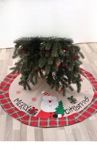 Detailed view of red plaid Christmas tree skirt with Santa Claus and Merry Christmas text