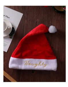 Dettaglio del cappello di Natale in peluche rosso con ricamo dorato Naughty sul bordo