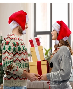Primo piano del ricamo dorato Merry sui cappelli di Babbo Natale in peluche rosso e bianco