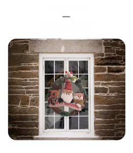 Detail of Christmas rattan wreath with Santa and Merry Christmas burlap banner on white window