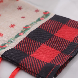 Christmas burlap wine bag with red snowflake patterns and black-red buffalo plaid drawstrings
