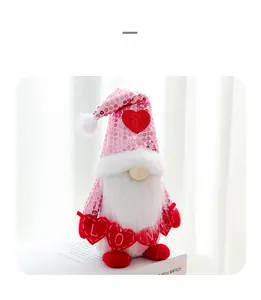 Detail of sequined pink gnome holding red LOVE heart charms on a white book decor