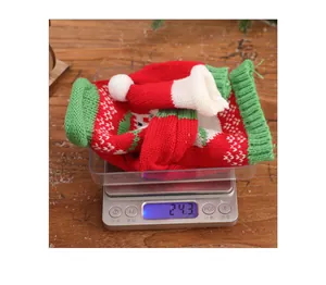 Detail view of a 24.3g knitted Christmas wine bottle cover with festive patterns