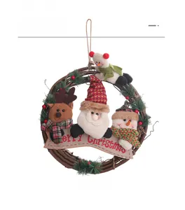 Detail of Christmas wreath featuring plush reindeer, Santa, and snowmen on a rattan circle