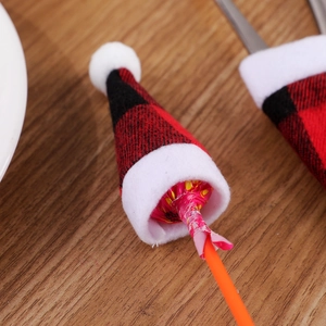 Mini Christmas plaid hat decoration for lollipops and cutlery on a wooden surface