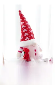Macro detail of Valentines gnome holding red roses on a stack of decorative books
