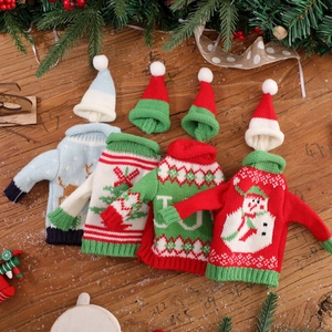 Miniature knitted Christmas sweater and hat sets with festive patterns on wood background